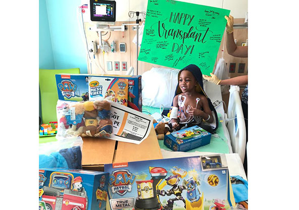 Olu sits on his hospital bed surrounded by toys on the day of his blood marrow transplant for sickle cell anemia.